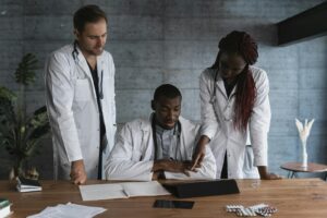 Doctors in discussion at a medical clinic, working on patient treatment plans.