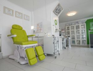 Professional equipment in doctor office with couch for medical treatment procedures behind protective screen